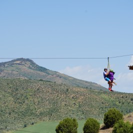 pair of zipliners soaring through Lava Zipline Adventure