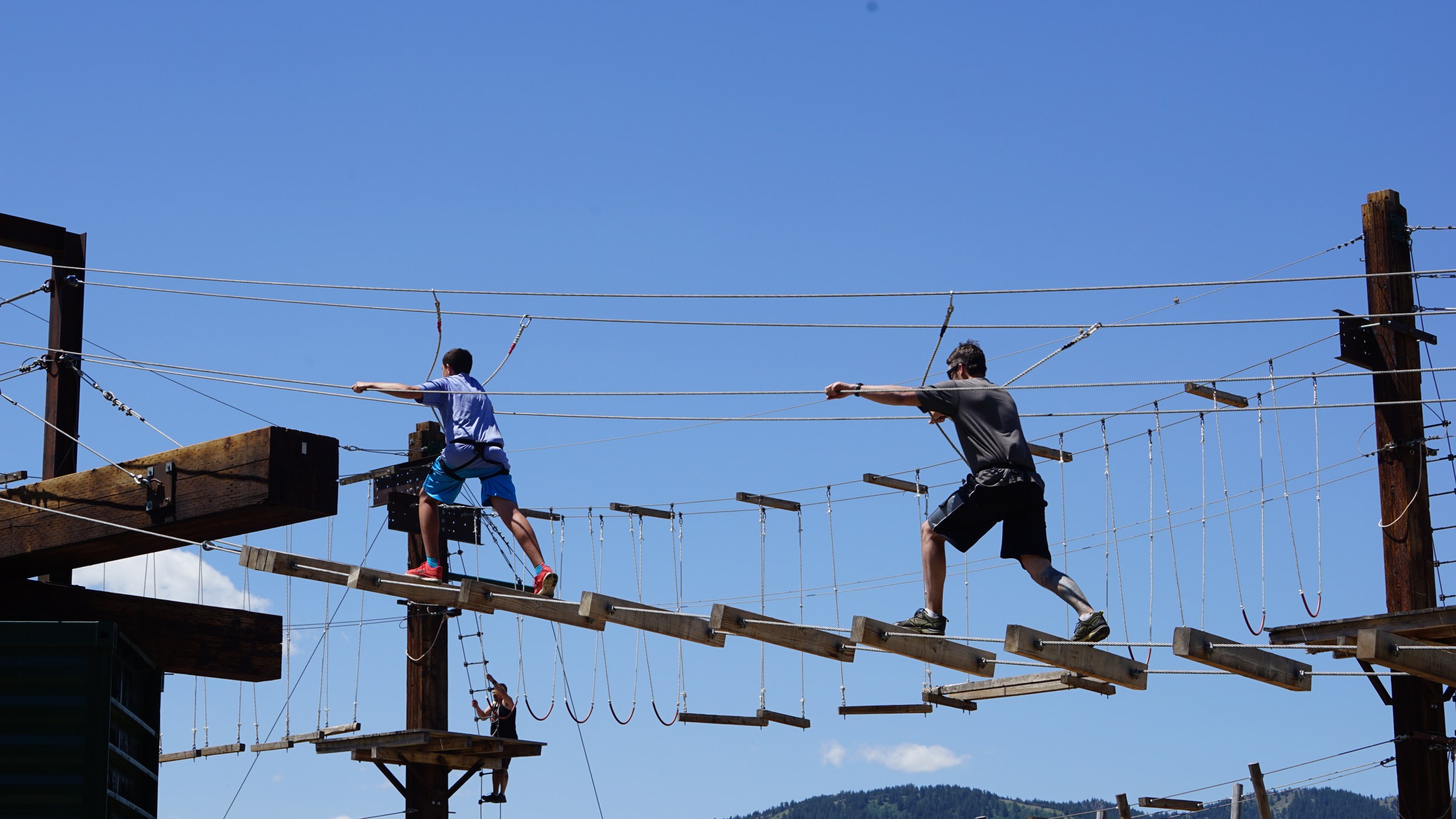 son and father running through the high ropes course in lava hot springs