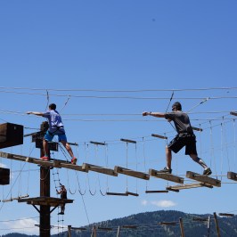 son and father running through the high ropes course in lava hot springs
