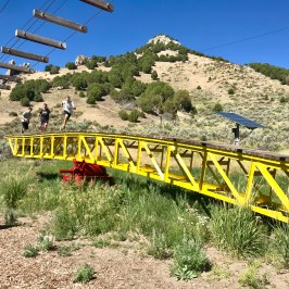 Kids running across giant teeder todder in adventure park