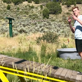 boy throwing a peace sign in the ropes course