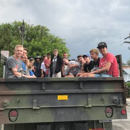 group of boys hanging out in the big green army truck