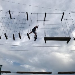 boy making his way across the high ropes course