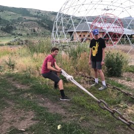 boy using ropes to pull chains in adventure park