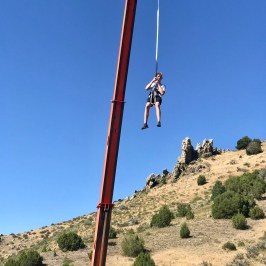 boy repelling down from the crane in adventure park