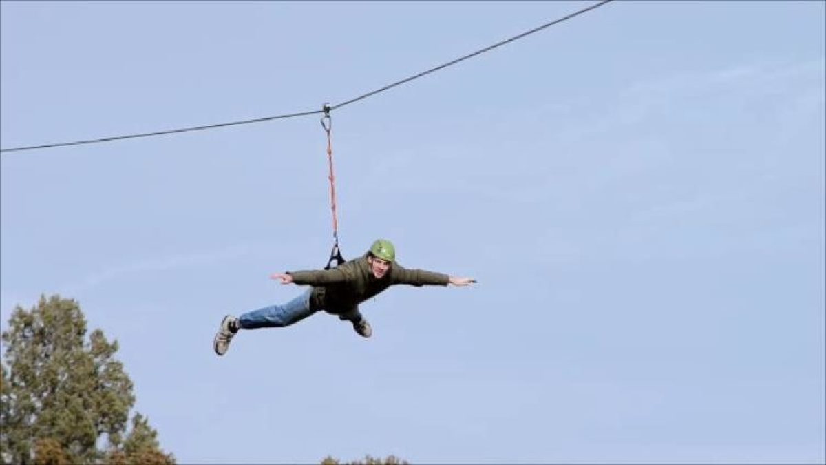 Man soaring on the zipline with no hands