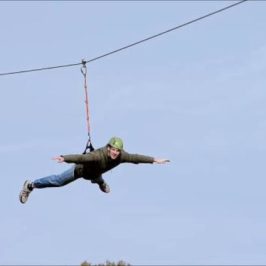 Man soaring on the zipline with no hands