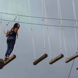 Woman anticipating her next move on the high ropes course