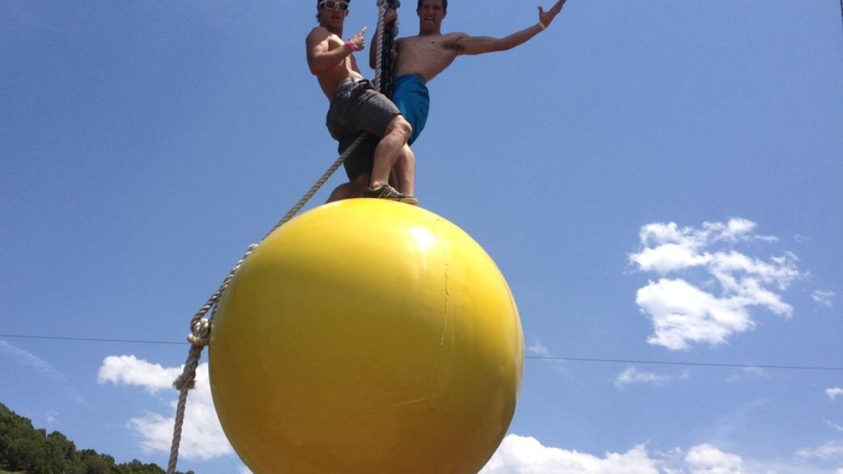guys being guys on the yellow ball of the adventure course in Lava Hot Springs