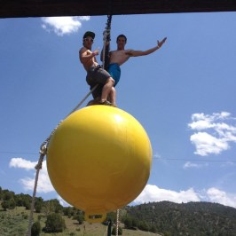 guys being guys on the yellow ball of the adventure course in Lava Hot Springs